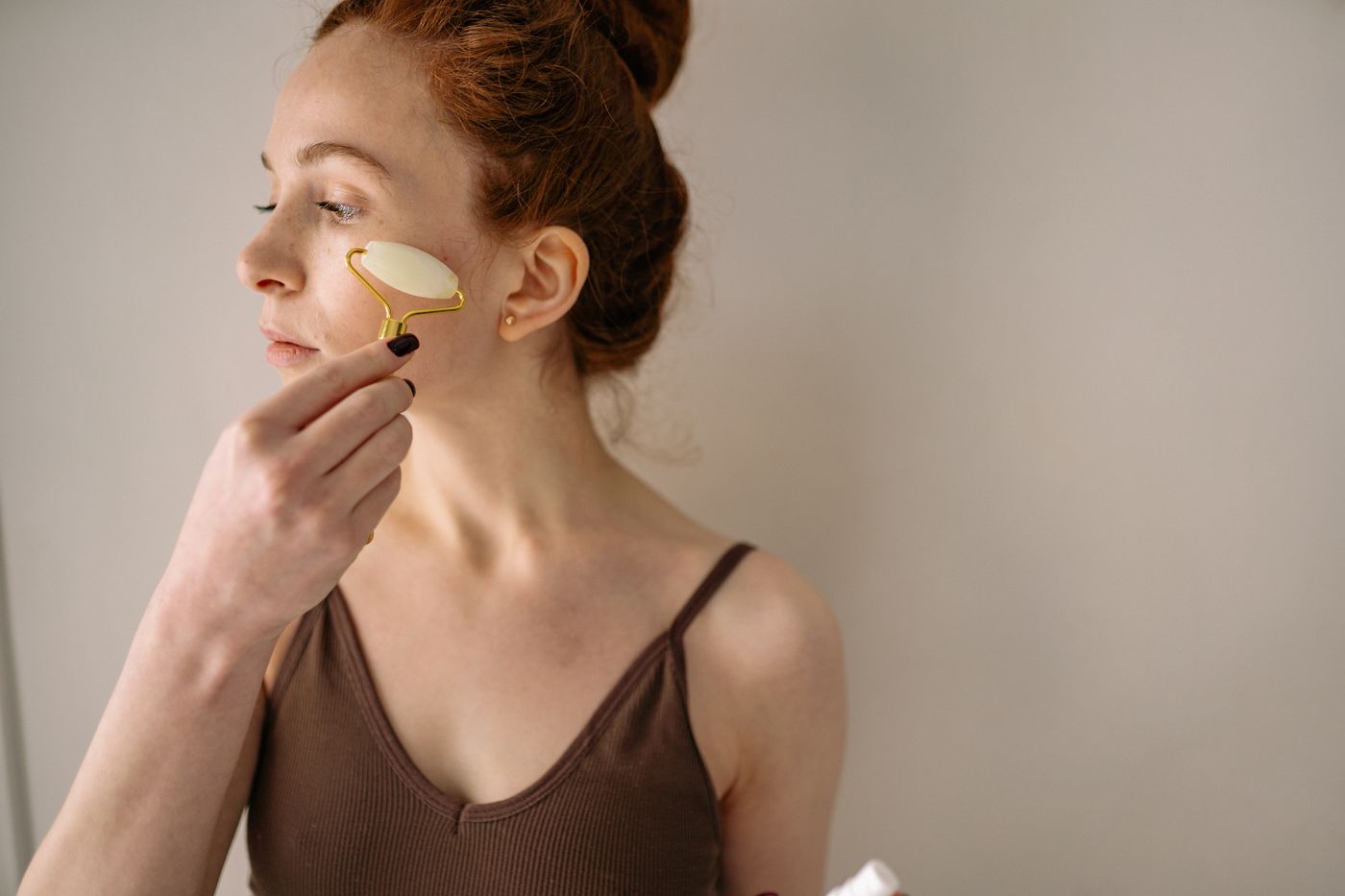 Femme utilisant un rouleau visage